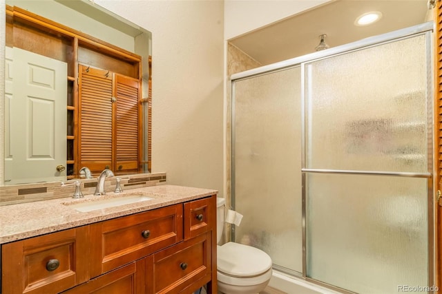 bathroom with vanity, toilet, and an enclosed shower