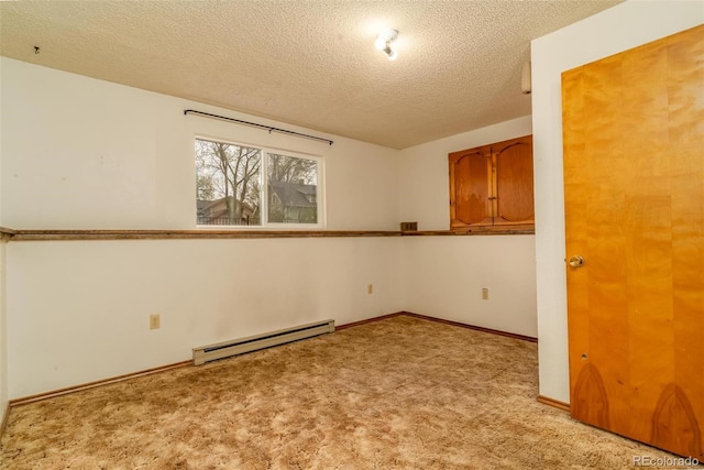 unfurnished room with a textured ceiling, a baseboard heating unit, and light colored carpet