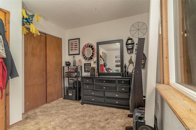 carpeted bedroom with a textured ceiling and a closet