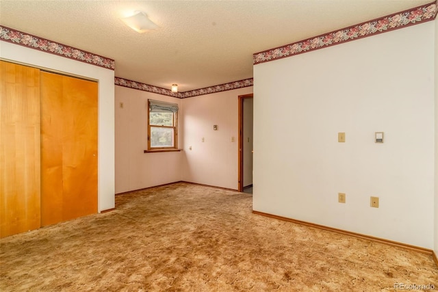 unfurnished bedroom featuring a textured ceiling, carpet floors, and a closet