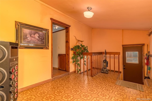 hallway featuring lofted ceiling and stacked washer / dryer