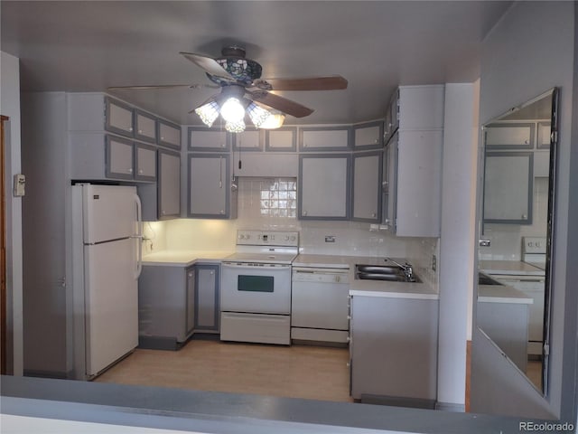 kitchen featuring white appliances, sink, decorative backsplash, and gray cabinetry