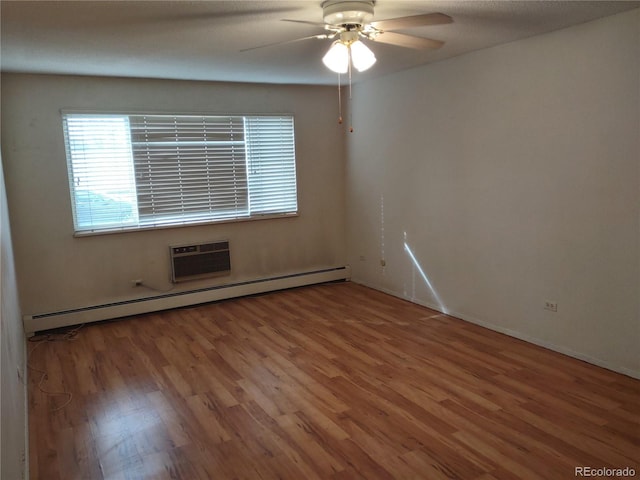 unfurnished room featuring hardwood / wood-style floors, a baseboard radiator, an AC wall unit, and ceiling fan