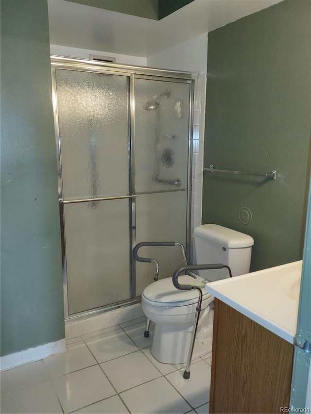 bathroom with vanity, toilet, a shower with shower door, and tile patterned flooring