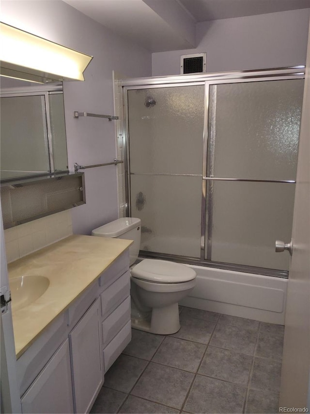 full bathroom featuring vanity, tile patterned floors, shower / bath combination with glass door, and toilet