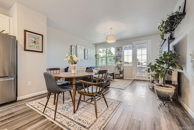 dining space with wood-type flooring