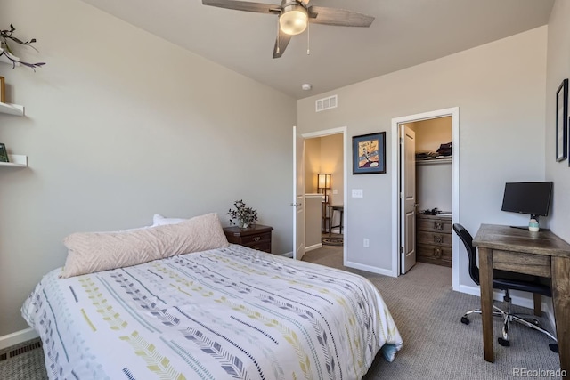 carpeted bedroom with ceiling fan, a walk in closet, and a closet