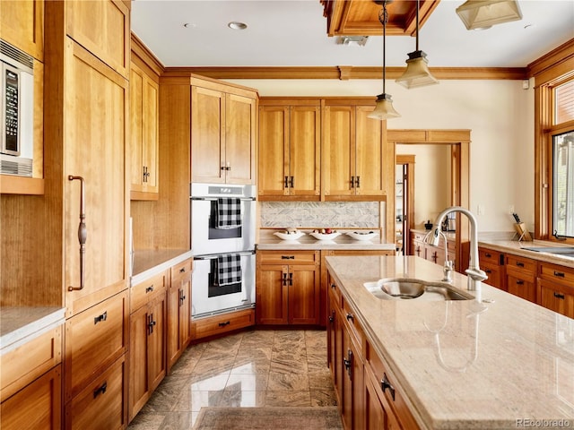6455 Dakota Ridge Dr, Golden, CO 80403 - kitchen with a sink, stainless steel appliances, crown molding, brown cabinetry, and hanging light fixtures