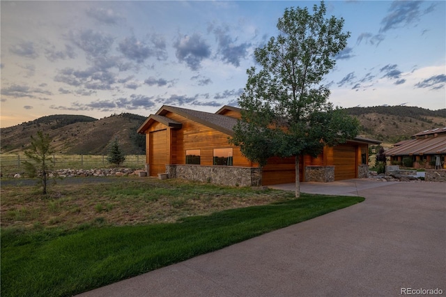 6455 Dakota Ridge Dr, Golden, CO 80403 - view of front of home with stone siding, a mountain view, concrete driveway, and an attached garage