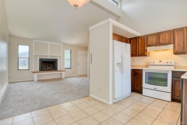 1419 Territory Trl, Colorado Springs, CO 80919 - kitchen featuring white appliances, under cabinet range hood, light countertops, light tile patterned flooring, and light colored carpet