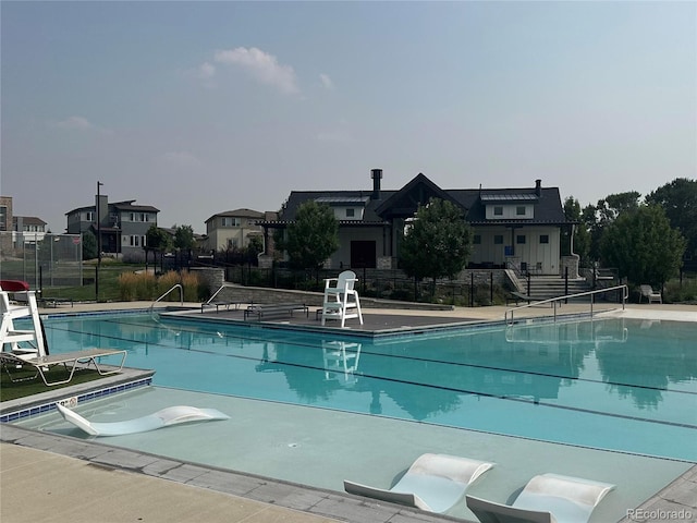 pool with a residential view, fence, and a patio