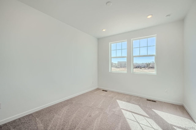 unfurnished room with recessed lighting, baseboards, visible vents, and light colored carpet