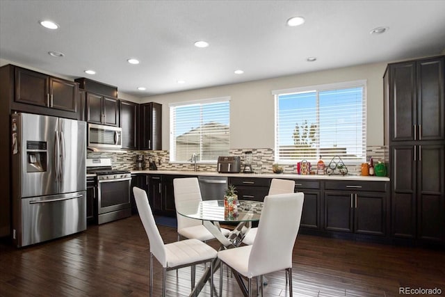 2521 Moline St, Aurora, CO 80010 - kitchen with appliances with stainless steel finishes, tasteful backsplash, dark wood-style flooring, recessed lighting, and light countertops