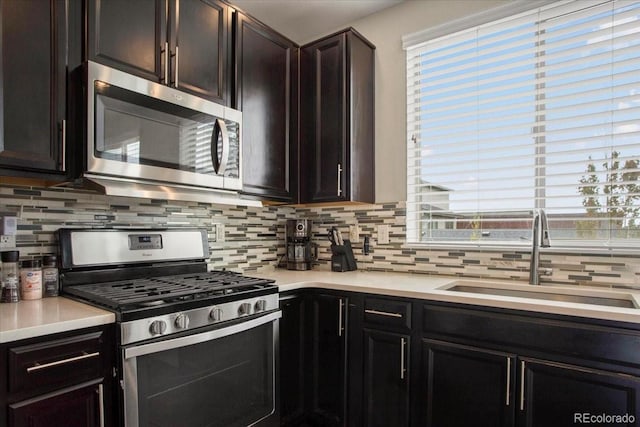 2521 Moline St, Aurora, CO 80010 - kitchen with appliances with stainless steel finishes, a sink, tasteful backsplash, and light countertops