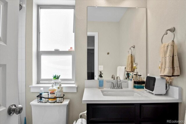 2521 Moline St, Aurora, CO 80010 - bathroom featuring toilet, vanity, and a shower
