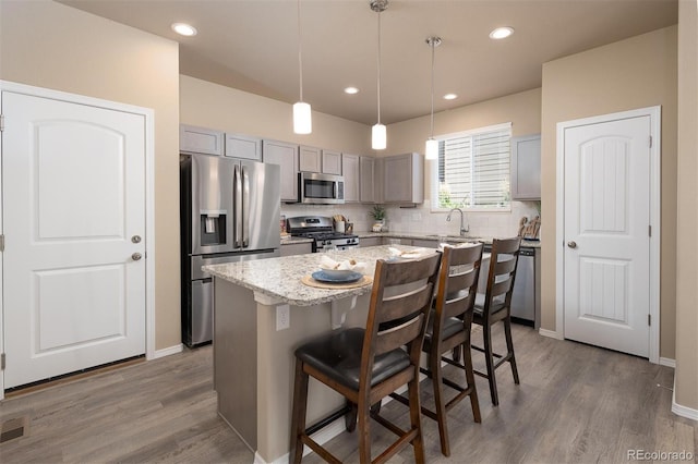 kitchen featuring gray cabinetry, appliances with stainless steel finishes, dark wood-type flooring, and a center island