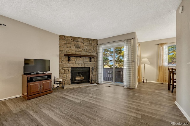 living room featuring a fireplace, wood-type flooring, and a textured ceiling