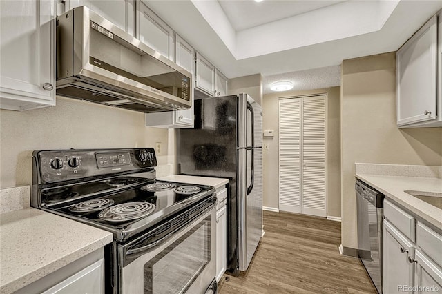 kitchen featuring stainless steel appliances, white cabinetry, and light hardwood / wood-style floors