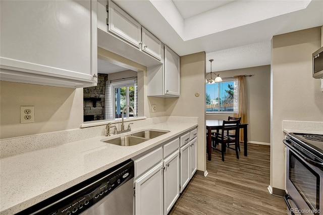 kitchen featuring white cabinetry, sink, pendant lighting, and appliances with stainless steel finishes