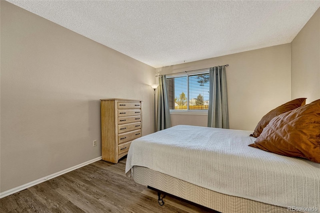 bedroom with dark wood-type flooring and a textured ceiling