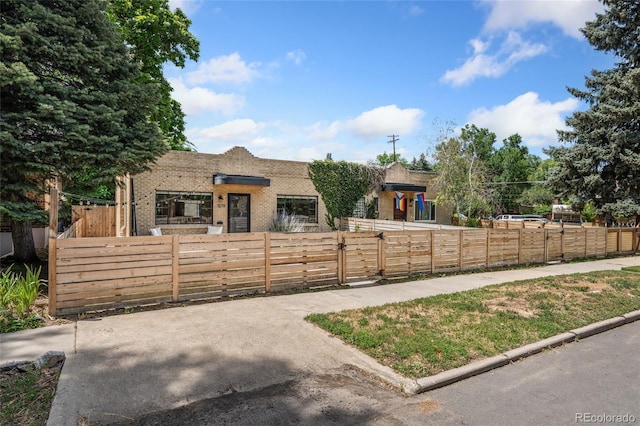 1579 Fairfax St, Denver, CO 80220 - view of front facade featuring brick siding, a fenced front yard, and a gate