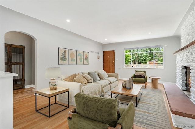 1579 Fairfax St, Denver, CO 80220 - living room with arched walkways, light wood-style flooring, a stone fireplace, and recessed lighting