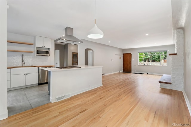 1579 Fairfax St, Denver, CO 80220 - kitchen with island exhaust hood, stainless steel appliances, arched walkways, white cabinets, and recessed lighting