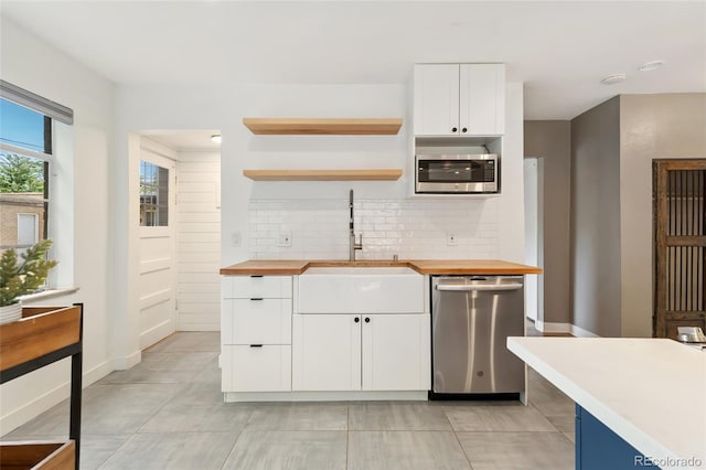 1579 Fairfax St, Denver, CO 80220 - kitchen with stainless steel appliances, wood counters, tasteful backsplash, open shelves, and white cabinetry