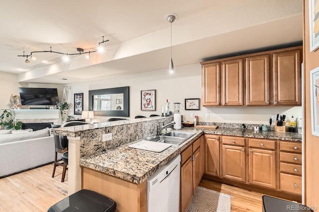 3030 Wyandot St Unit 7, Denver, CO 80211 - kitchen featuring white dishwasher, a peninsula, light wood-type flooring, open floor plan, and a kitchen breakfast bar
