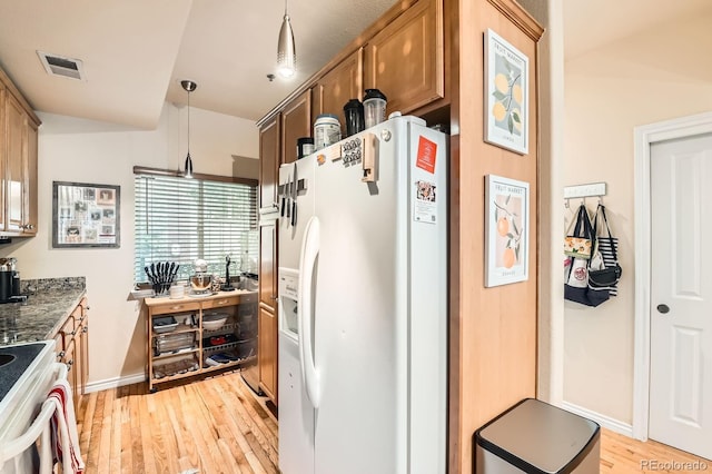 3030 Wyandot St Unit 7, Denver, CO 80211 - kitchen featuring white fridge with ice dispenser, stove, light wood-type flooring, hanging light fixtures, and dark stone counters