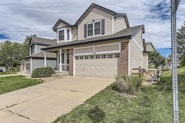 view of front of property featuring a front yard, a porch, and a garage