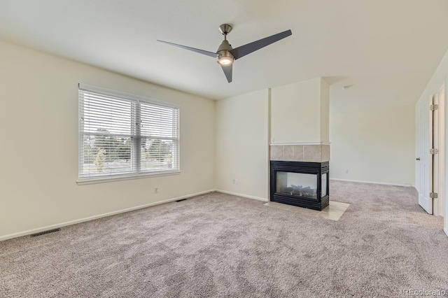 unfurnished living room featuring ceiling fan, a fireplace, and light carpet