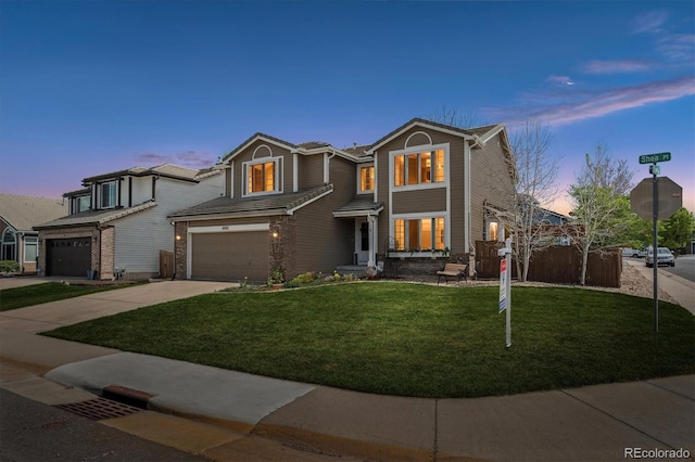 view of front of house with concrete driveway, fence, a front yard, and a garage