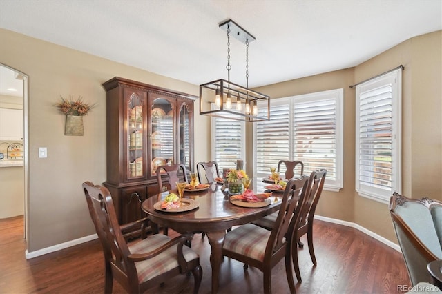 dining area with baseboards, a notable chandelier, dark wood-style floors, and arched walkways
