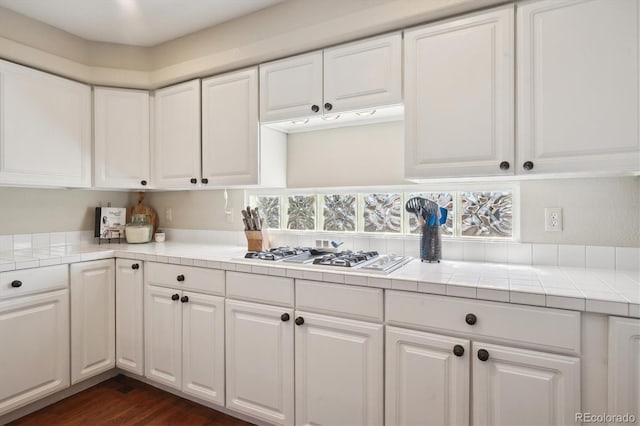 kitchen featuring tile counters, white gas stovetop, and white cabinets