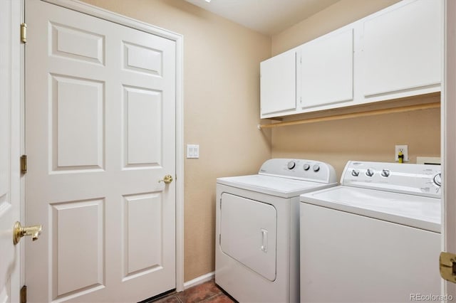 laundry area with dark tile patterned floors, cabinet space, and washer and dryer