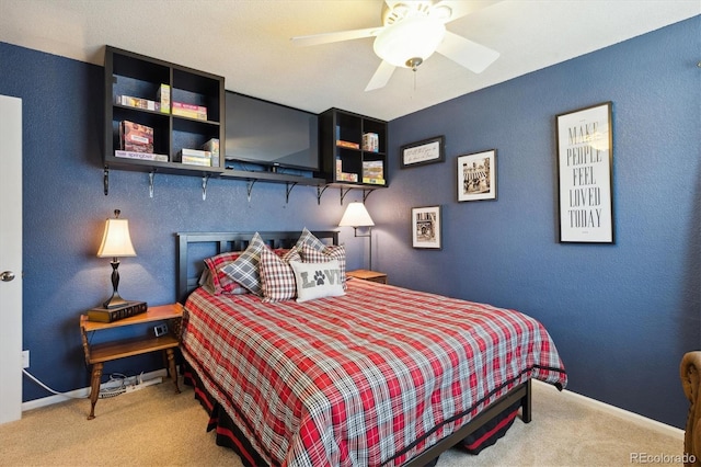 carpeted bedroom with a ceiling fan and baseboards