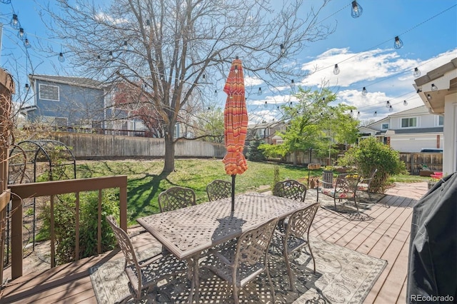 wooden terrace featuring a fenced backyard, a yard, and outdoor dining space