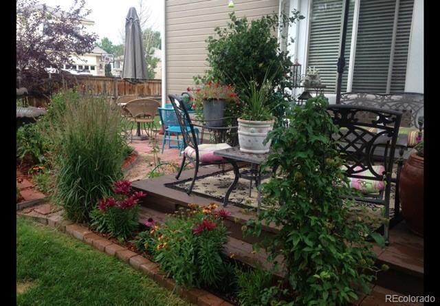 view of patio with outdoor dining area, fence, and a deck