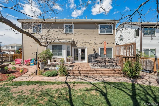 back of property featuring fence, a patio, a lawn, and french doors