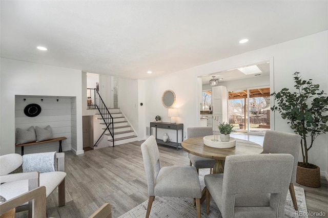 dining space with light wood finished floors, stairway, and recessed lighting