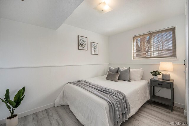 bedroom featuring light wood-style floors and baseboards