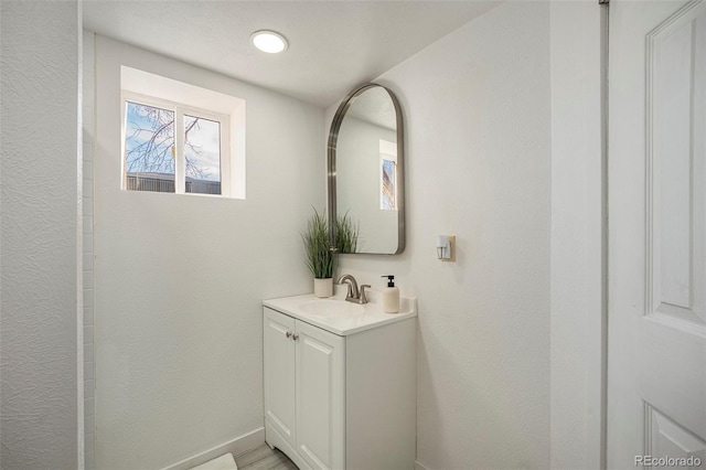 bathroom featuring vanity and a textured wall