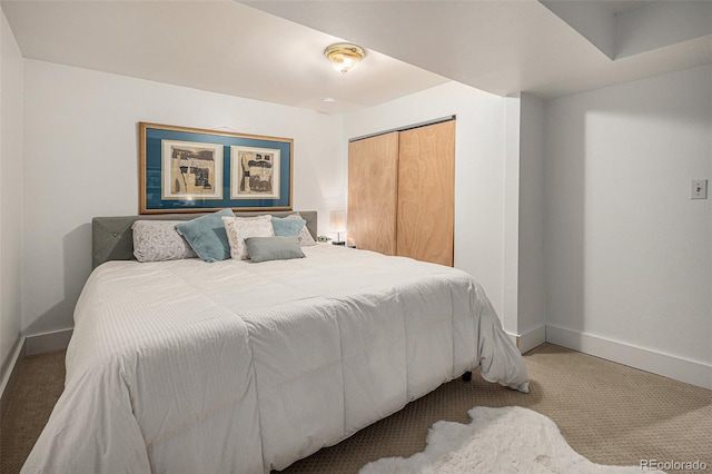 bedroom with baseboards, carpet floors, and a closet