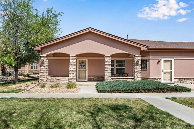 15501 E 112th Ave Unit 33D, Commerce City, CO 80022 - view of front of house with a porch, stucco siding, a front yard, and stone siding