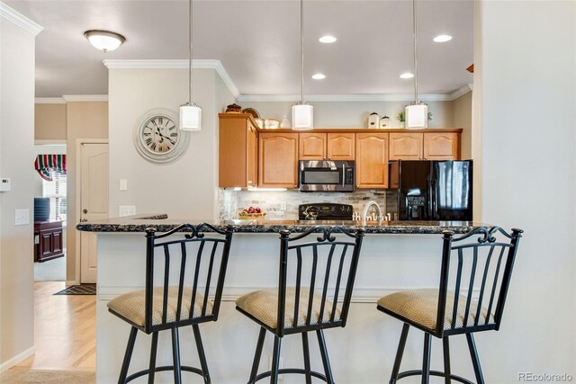15501 E 112th Ave Unit 33D, Commerce City, CO 80022 - kitchen with crown molding, backsplash, black appliances, and a breakfast bar