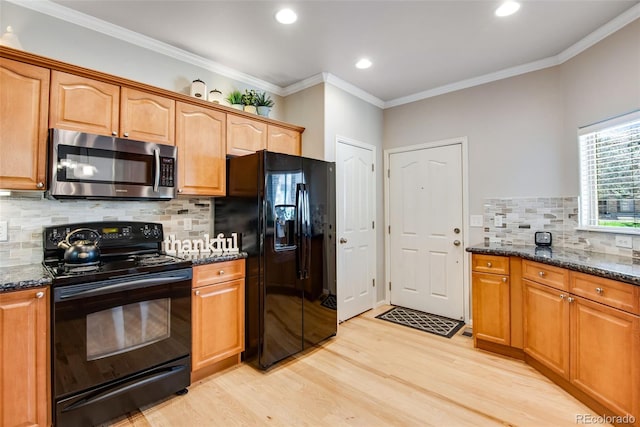 kitchen with dark stone counters, light wood-style flooring, backsplash, and black appliances