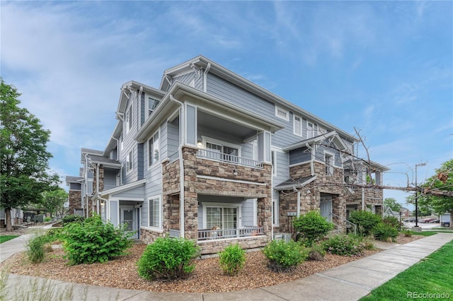 5255 Memphis St Unit 1009, Denver, CO 80239 - view of side of home featuring stone siding, a balcony, and covered porch