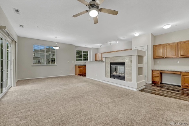 5255 Memphis St Unit 1009, Denver, CO 80239 - unfurnished living room with a tile fireplace, ceiling fan, and dark colored carpet