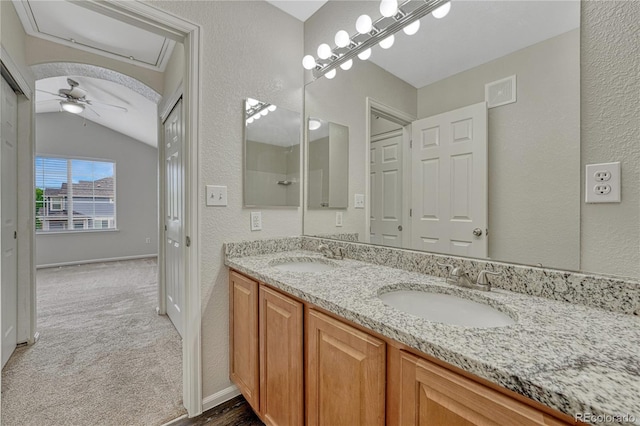 5255 Memphis St Unit 1009, Denver, CO 80239 - bathroom with vaulted ceiling, double vanity, a ceiling fan, and a textured wall